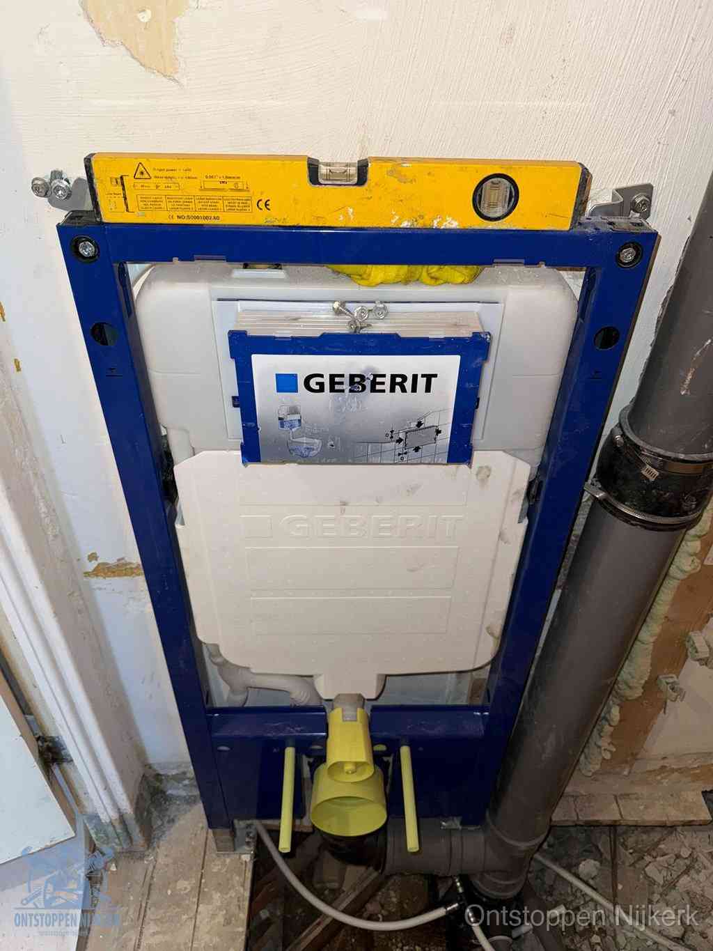 Een Geberit inbouwreservoir met frame voor een hangtoilet tegen de wand, met de afvoerbocht naar de vloer, kenmerkend voor een verstopt hangtoilet in Nijkerk