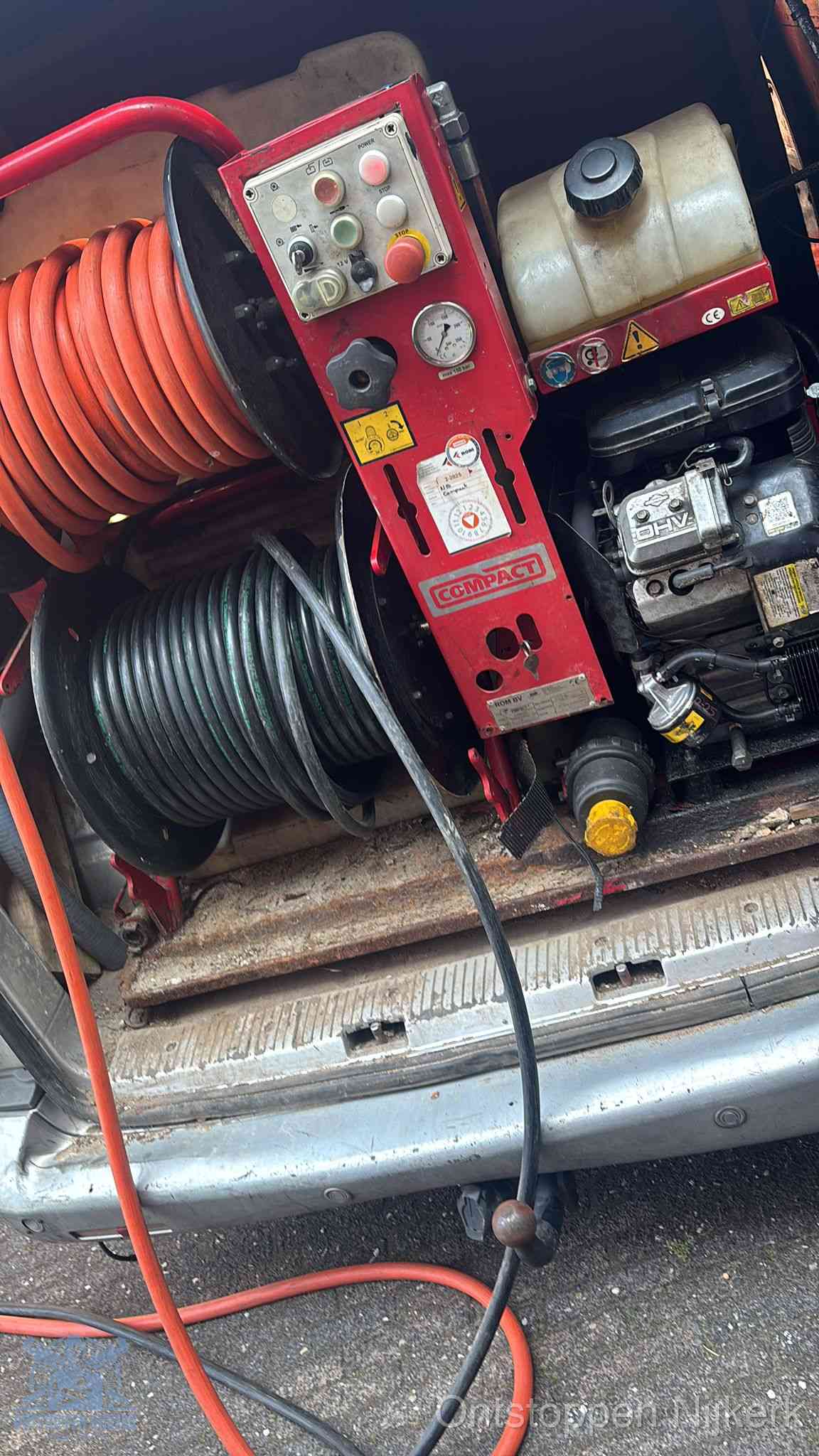 Een rood hogedruk-rioolreinigingstoestel met slangen in de laadbak van de bedrijfsbus, apparatuur voor een hardnekkige wc-verstopping in Nijkerk