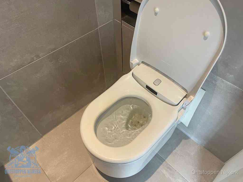 Een toiletpot vol troebel water met drijvend papier en restanten, de meest voorkomende oorzaak van een verstopte wc in Nijkerk