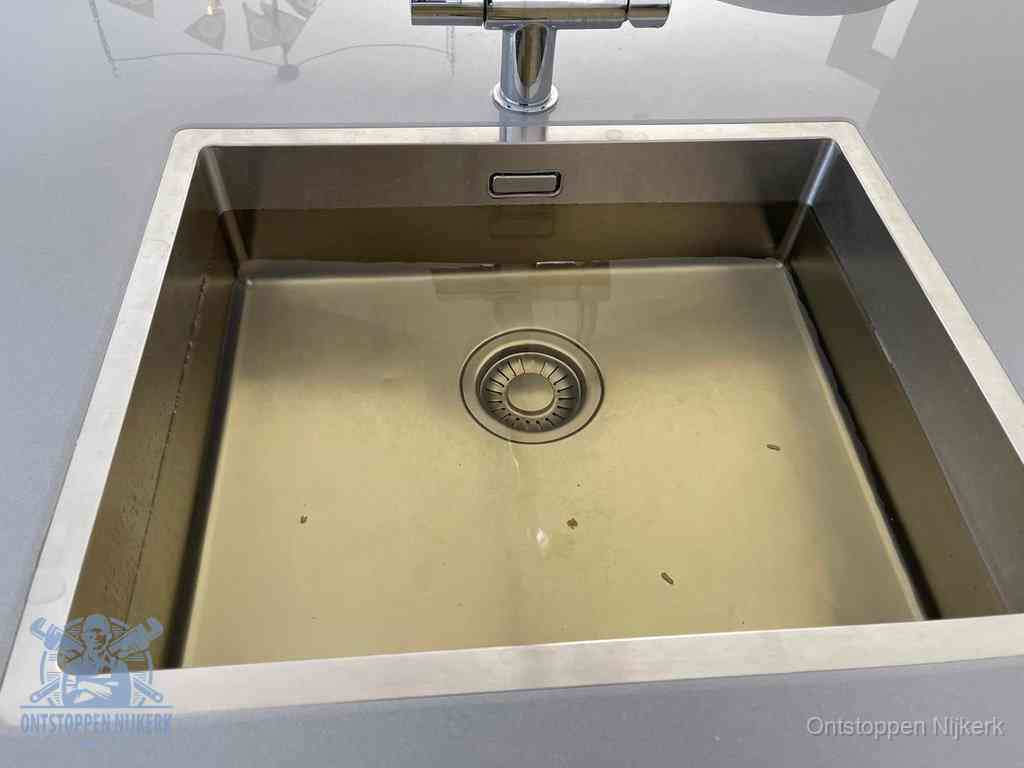 Stilstaand water in een rvs spoelbak dat niet wegloopt, een duidelijk signaal van een gootsteenverstopping in Nijkerk